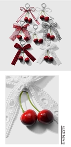 Detailed macro view of red cherry keychain with delicate lace bow and pearl charm