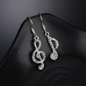 Elegante silberne Musiknoten-Ohrringe mit glitzernden Kristallen auf Schwarz