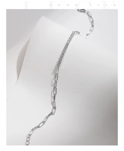 Detail of silver paperclip chain bracelet with a bar of sparkling round moissanite stones