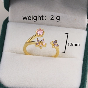 Détail de la bague fleur dorée avec cristaux roses et mauves et mesure d'ouverture de 12 mm
