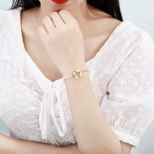 Elegant gold roman numeral bracelet with rhinestones worn on a female wrist