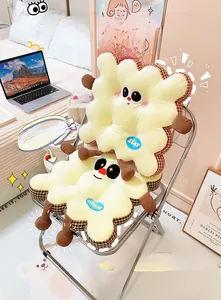 Detail of soft biscuit-shaped cushion with grid border and cute cartoon embroidery