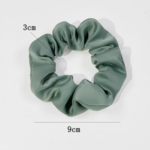 Deep green satin silk scrunchie with 9cm outer diameter and 3cm width on white background