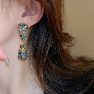Détail de boucle d'oreille bohème vintage avec strass colorés et breloque en verre gris