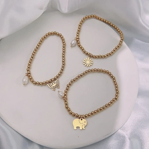 Set of three 18k gold plated beaded bracelets featuring butterfly, sunflower, and elephant charms