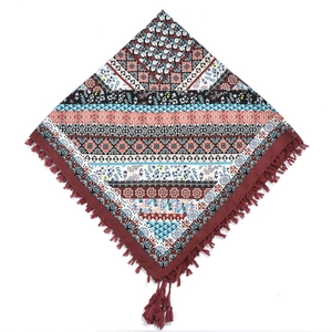 Detail of bohemian square scarf featuring ethnic jacquard patterns and dark red tassels