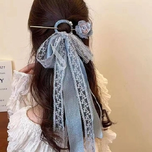 Detailed view of light blue lace bow hairpin with mesh rose and pearl accents