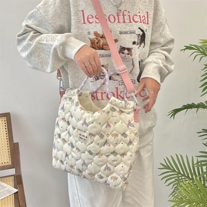 Detail of white quilted canvas tote with cute animal prints and woven handles