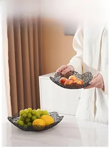 Detail of minimalist black metal wire fruit basket with wavy edges and mesh design