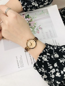 Close-up of GEDI vintage watch featuring a gold case and brown leather strap on wrist
