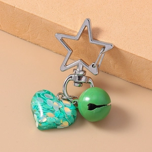 Detail of green resin heart keychain with star clasp, bell, and sparkling sequins