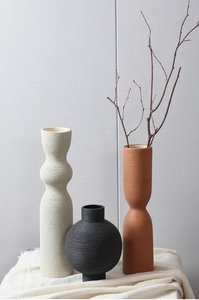 Minimalist Nordic ceramic vases with handmade brushed textures on white wrinkled fabric