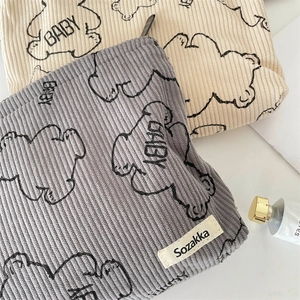 Close-up of corduroy makeup bag with cute bear prints and soft striped texture details