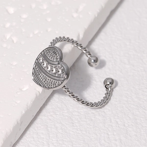 Vue macro détaillée d'une bague ouverte en forme de cœur avec motif martelé argenté