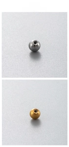 Macro detail of stainless steel screw-back piercing balls in silver and gold finish