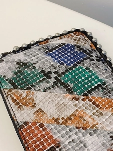 Chic snakeskin patchwork envelope bag with colorful patterns and metallic silver studs