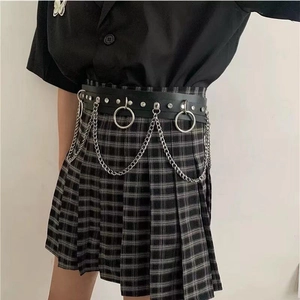 Detail eines schwarzen Punk-Gürtels mit silbernen Metallketten und Ringen am Faltenrock