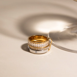 Macro shot of three stacked rings featuring 18K gold and silver plating with white zircon stones