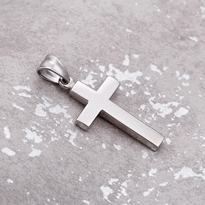 Macro shot of silver cross pendant with polished finish and metal texture background
