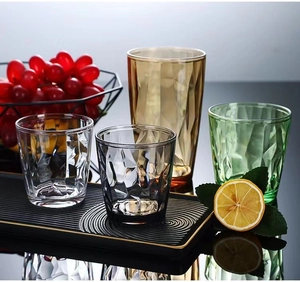 Colorful geometric acrylic tumblers in amber and green on a premium black ripple tray