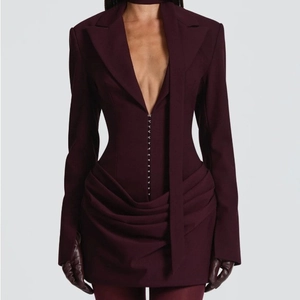 Dettaglio dell'abito blazer bordeaux aderente con bottoni in vita e orlo a pieghe