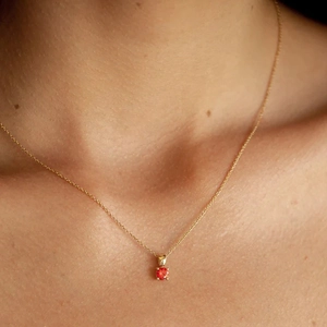 Close-up of S925 silver gold necklace featuring a round red garnet gemstone pendant