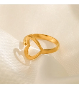 Artistic shadow of heart-shaped gold ring on silk fabric under natural warm light