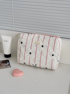 Detail of pink starry geometric makeup bag with quilted fabric and zipper closure