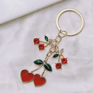 Cute cherry heart keychain with red rhinestones and gold-plated metal ring for bags