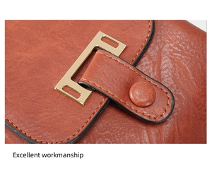 Macro view of textured brown leather backpack flap with golden metal buckle and stitching