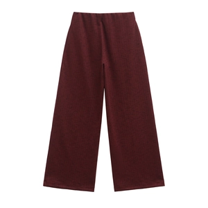 Dettaglio dei pantaloni bordeaux a gamba larga con trama in maglia e taglio a vita alta