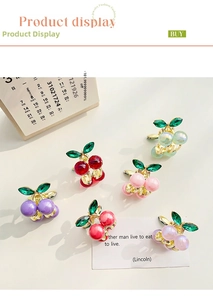 Macro shot of colorful alloy cherry hair clips with green rhinestones on desktop