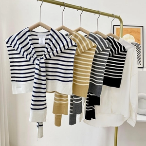 Knitted striped shawl wrap collars in navy, khaki, grey, and black displayed on hangers