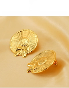 Vue macro détaillée des boucles d'oreilles nœud en acier titane plaqué or 18 carats