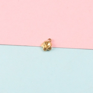 Close-up of golden flower-shaped stainless steel pendant tray for jewelry making