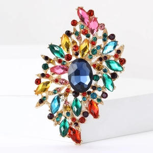 Detailed close-up of large blue crystal brooch with multi-color rhinestones on gold setting