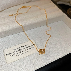 Detailed macro of 18k gold plated cylinder pendant necklace with sparkling zircons