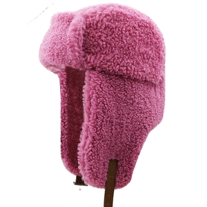 Detailed view of pink faux shearling trapper hat with earflaps and brown leather chin strap