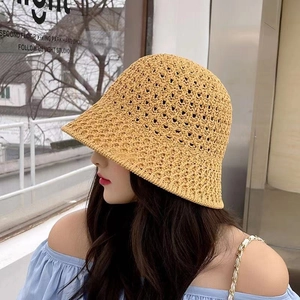 Close-up of ginger yellow hollow knit bucket hat with intricate woven straw texture