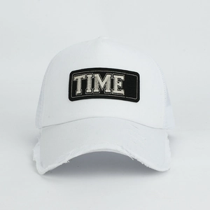 Close-up of white mesh trucker hat with TIME letter patch and distressed brim detail