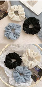 Detail of tweed hair scrunchies with faux pearl trim and subtle sequins in three colors