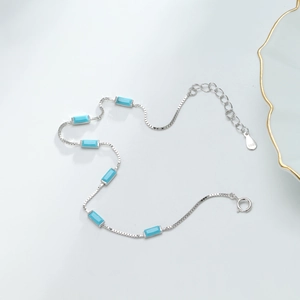 Detail of 925 sterling silver box chain bracelet with blue rectangular gemstones