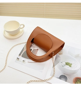 Flat lay of brown litchi pattern mini bag with gold chain strap on a white table