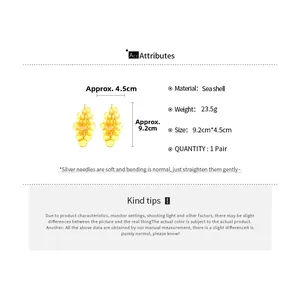 Detail view of yellow seashell tassel earrings with silver needles and shell layers