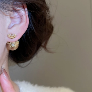 Detailed close-up of vintage style crown stud earrings with pearl drop and crystal accents