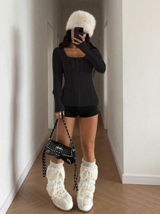 Detail of square neck black cable knit sweater styled with faux fur hat and shoulder bag
