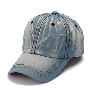 Detailed view of tie-dye denim baseball cap with contrast stitching and metal eyelets