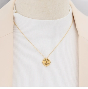Détail du collier trèfle magnétique plaqué or 18K sur mannequin en tricot blanc