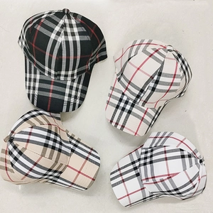 Dettaglio dei cappellini da baseball a quadri nei colori nero, beige, bianco e grigio