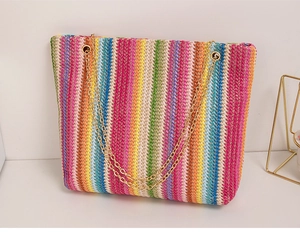 Detail of multi-color rainbow woven tote bag featuring gold-tone chain shoulder straps